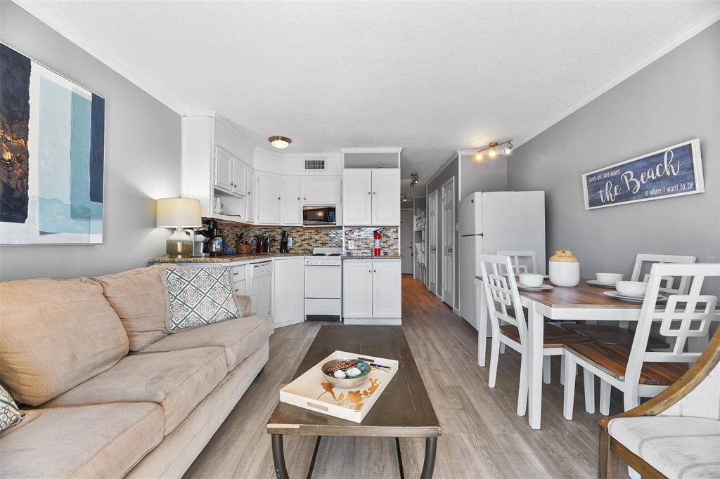 A cozy living and kitchen area opens up to a balcony where you can take in the calming sights and sounds of the beach.