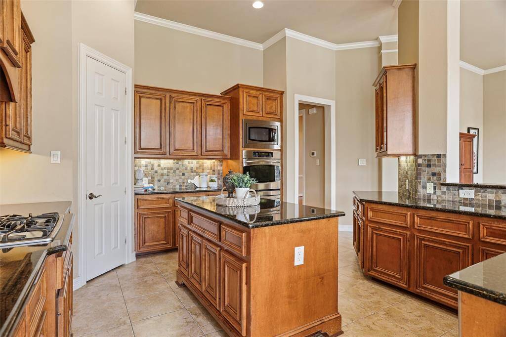 Experience culinary excellence in this kitchen featuring a central island, sleek gas stovetop, and the perfect nook for your dream coffee station.