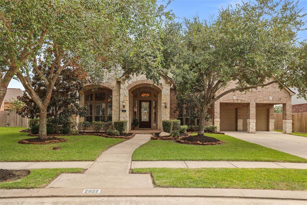 Discover this enchanting single-story residence, nestled amidst lush mature trees with tasteful stone detailing and an inviting arched entrance. Complete with a spacious two-car garage, this home is a gem in a serene community setting.