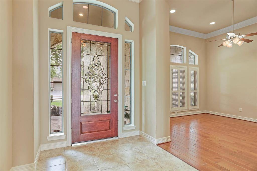 Welcome home through an elegant mahogany entryway with intricate leaded glass detailing.