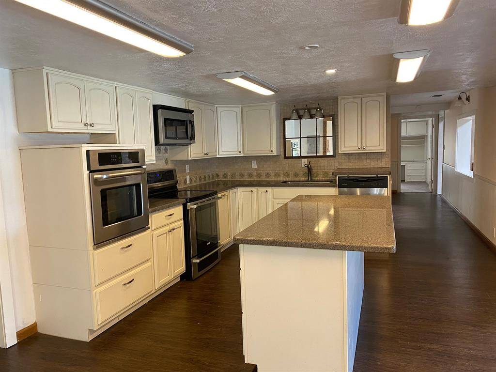 Spacious kitchen with island and stainless steel appliances