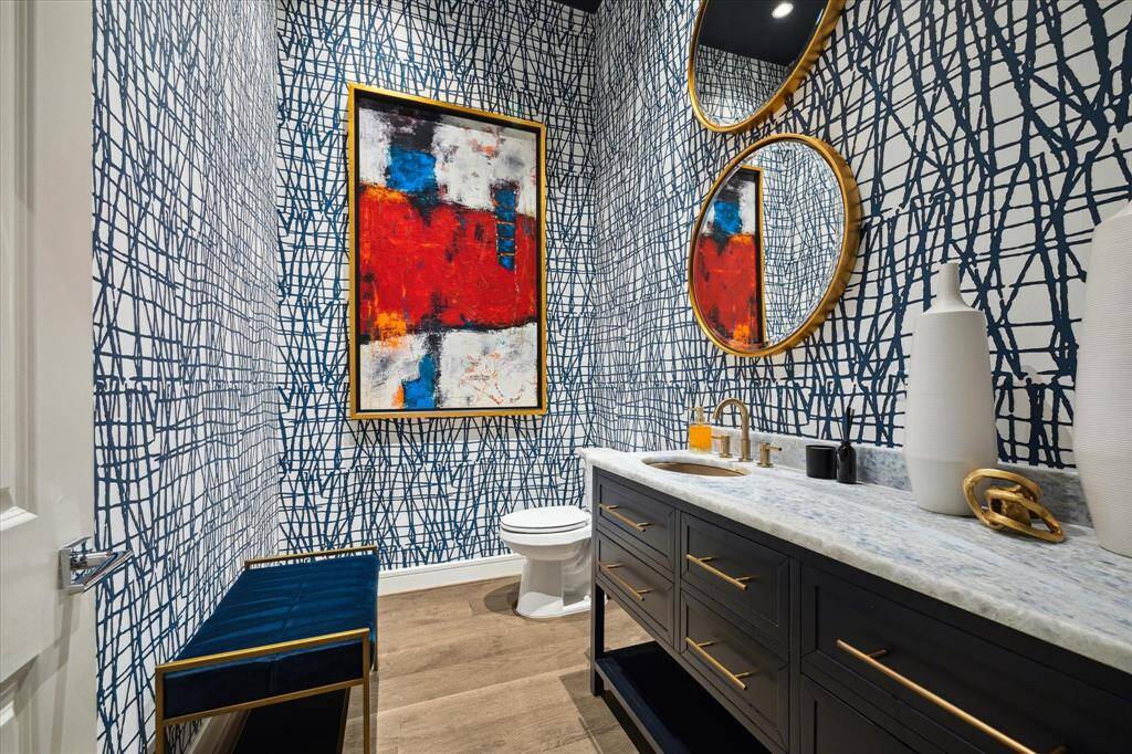 Chic guest bath with bold, artistic wallpaper and modern finishes.