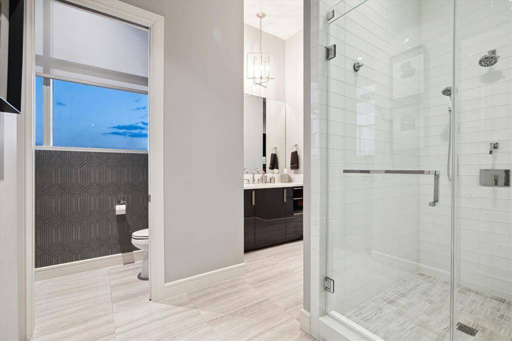 Elegant ensuite with secluded commode and glass-enclosed shower.