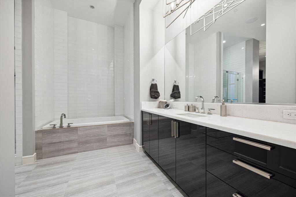 Ensuite Oasis: Featuring a sleek soaking tub, spacious glass-enclosed shower, and a modern double vanity.