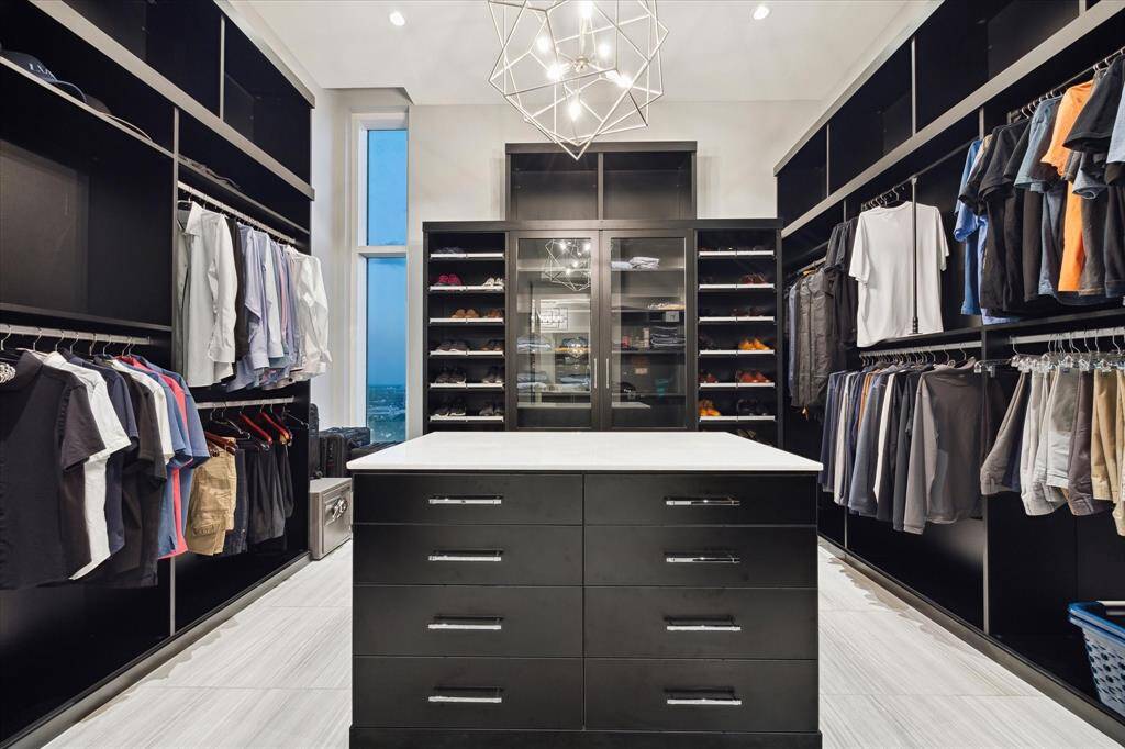 Discover the elegance of this spacious, sophisticated black walk-in closet, boasting premium finishes with ample room for two.