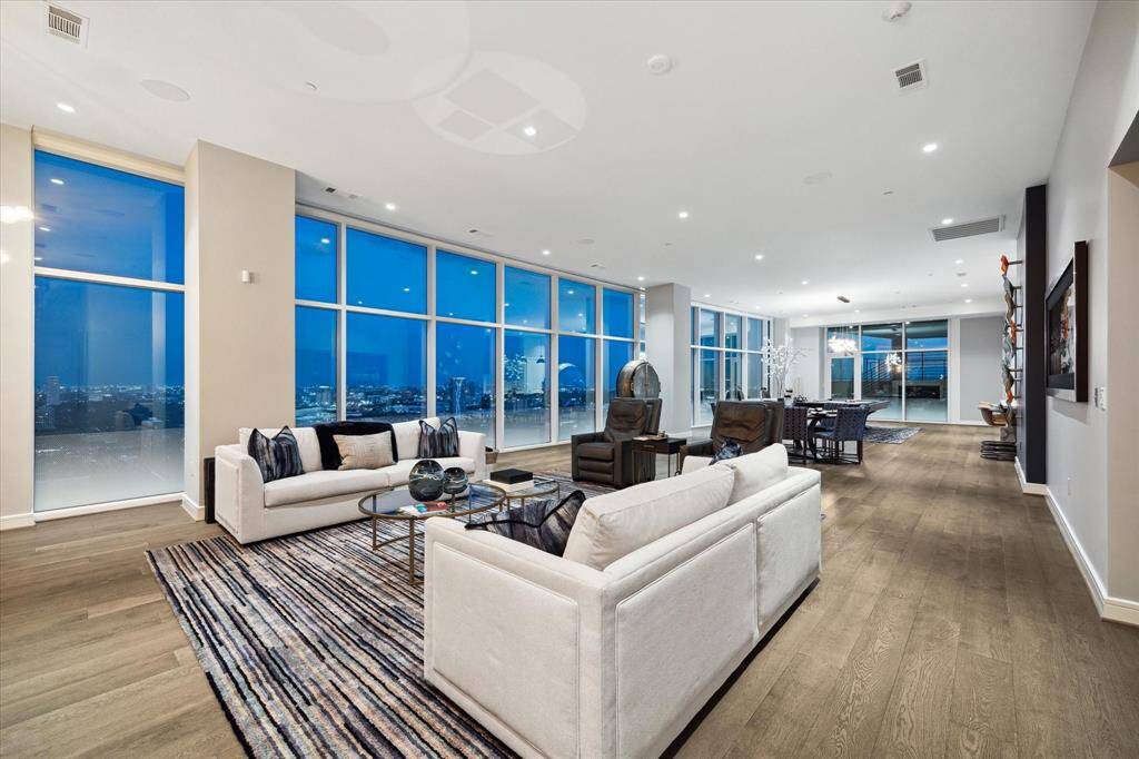 Inviting living room with expansive windows that showcase breathtaking city views and ample natural light