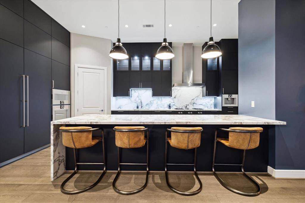 Sleek, contemporary kitchen with premium stainless steel appliances and expansive marble island.