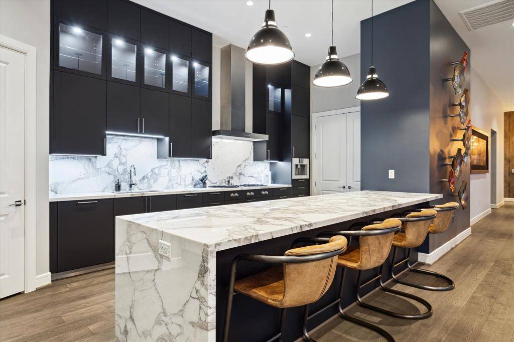 You can cook everything in this sleek chef's kitchen featuring elegant marble countertops and contemporary finishes.