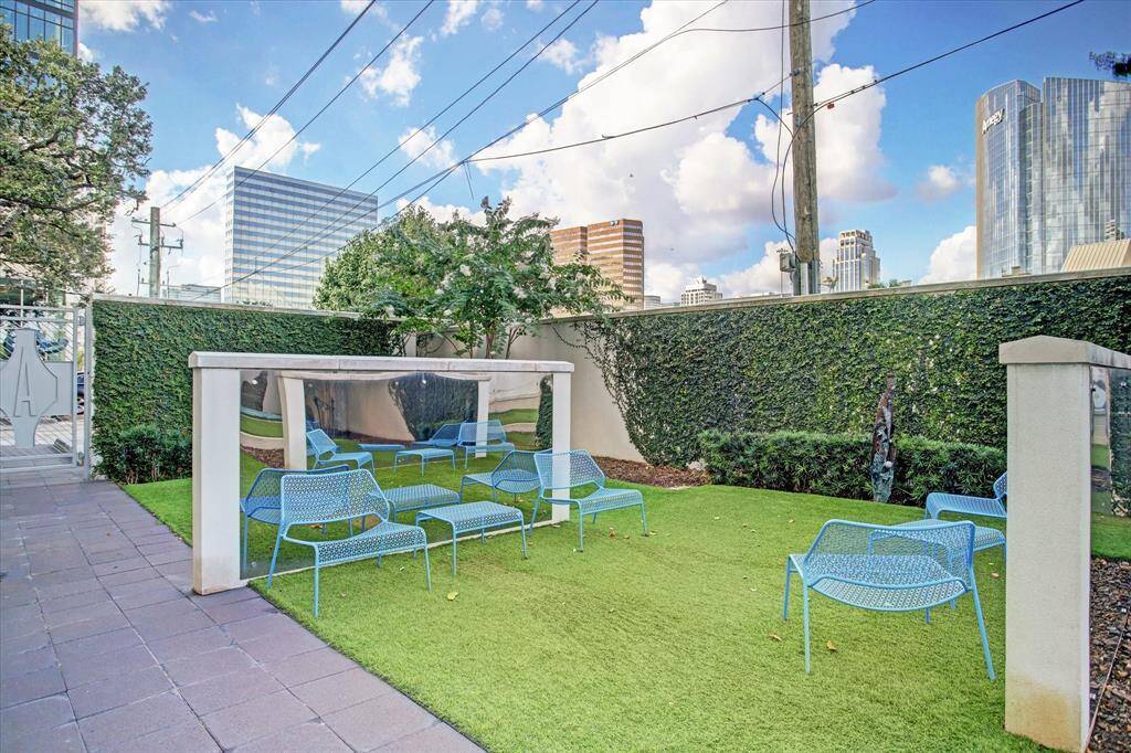 Enjoy an exclusive, landscaped dog park with comfortable seating, nestled within a vibrant urban setting.