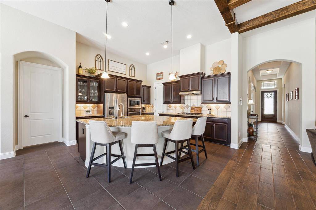 Oversized kitchen island with pull out trash can, 2 glass doors.  Walk in pantry, upgraded cabinetry including 4" crown on top, gas