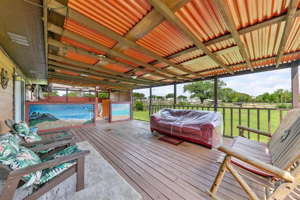 The expansive back covered deck offers plenty of space for outdoor entertaining and relaxation, perfect for enjoying the surrounding nature.
