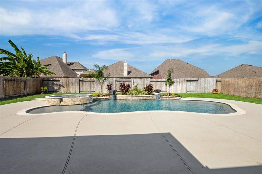 12,529 gallon pool with fire/water bowls, travertine coping, stacked travertine overflow from hot tub.