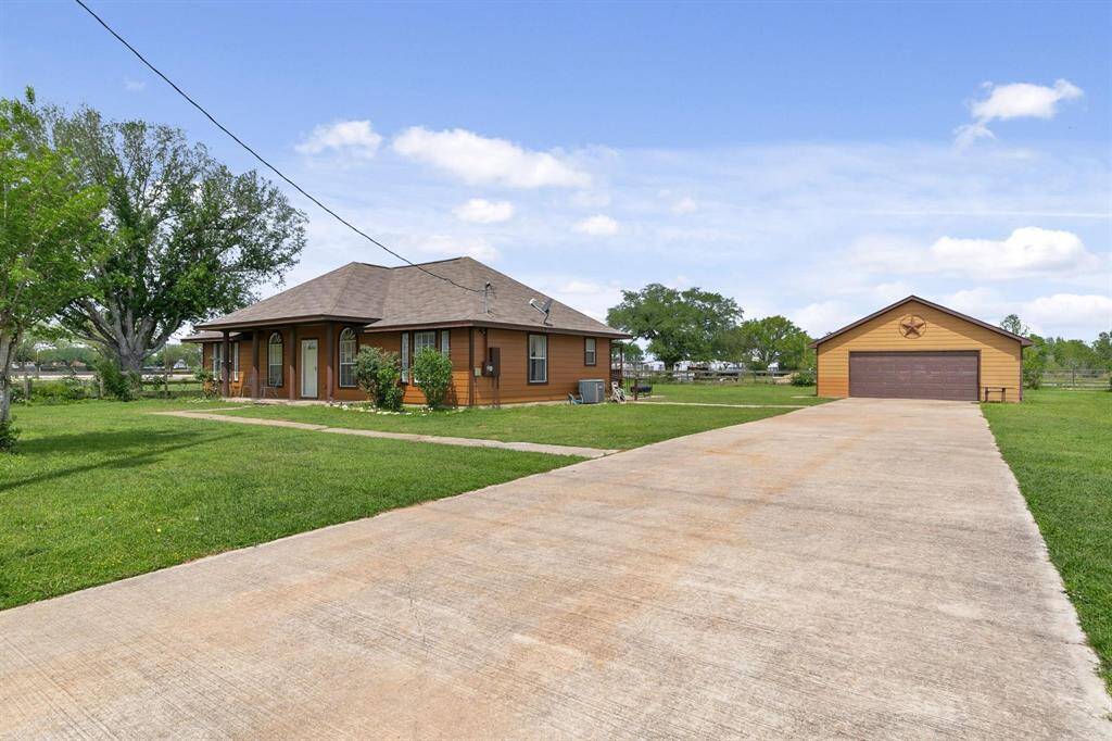 The driveway leads to ample parking options, including an RV spot,