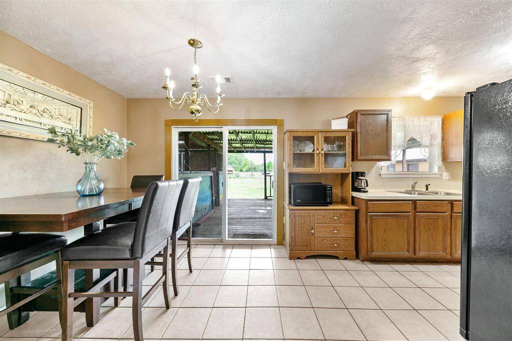 Cozy eat-in kitchen area with classic wooden cabinetry and tiled flooring.