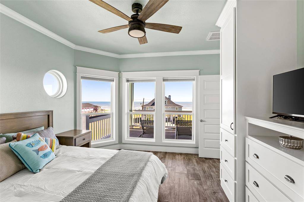 2nd floor beachside view bedroom, featuring a balcony, contemporary ceiling fan, and built-in storage.