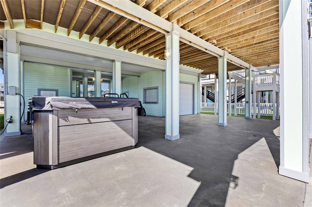 Covered outdoor area featuring a hot tub, with ample room for entertaining or relaxing.