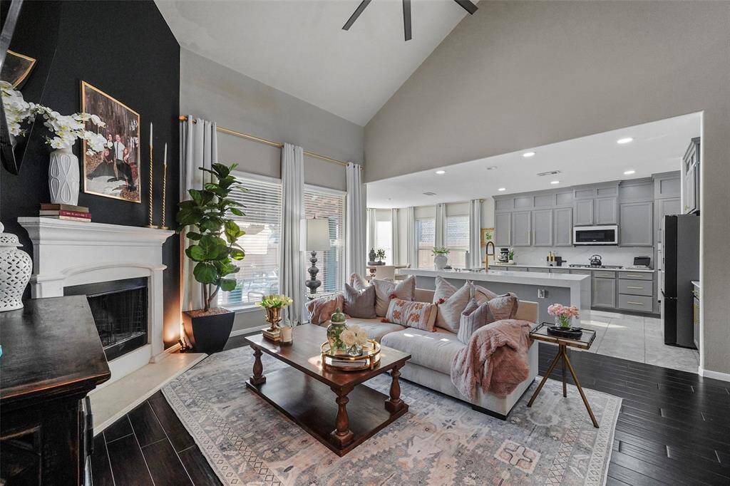 Cozy corner fireplace is the focal point with black accent wall.