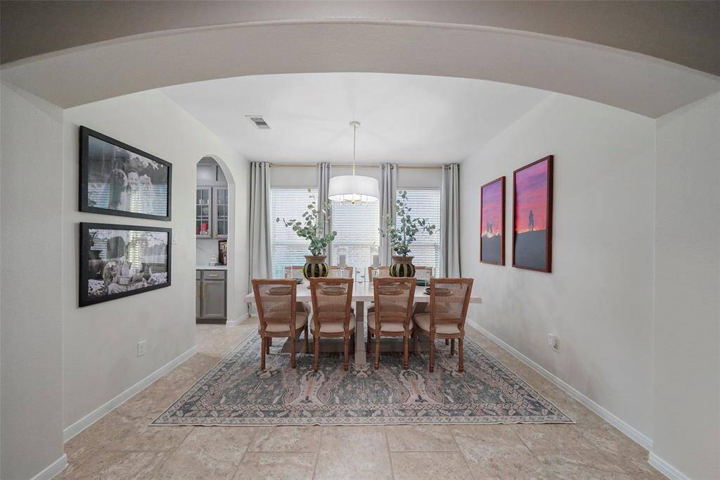 Formal dining room with arched entry and large windows for plenty of natural light.