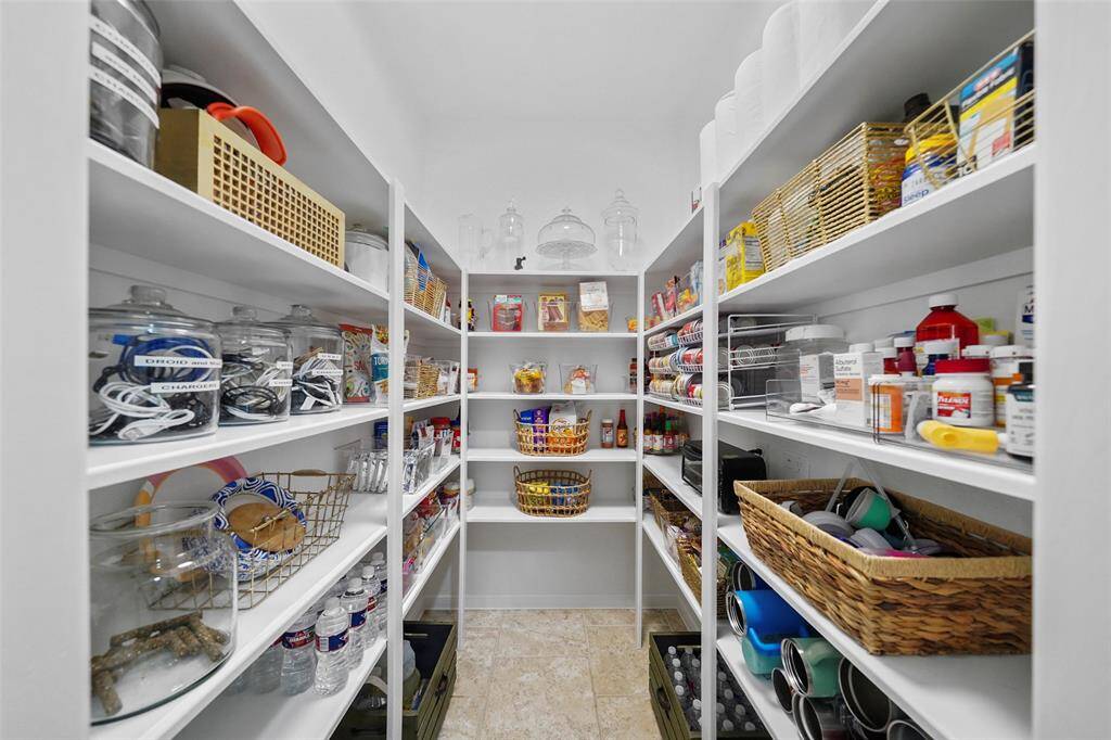 Large walk in pantry with shelving for food, small appliance ad extra dish storage.