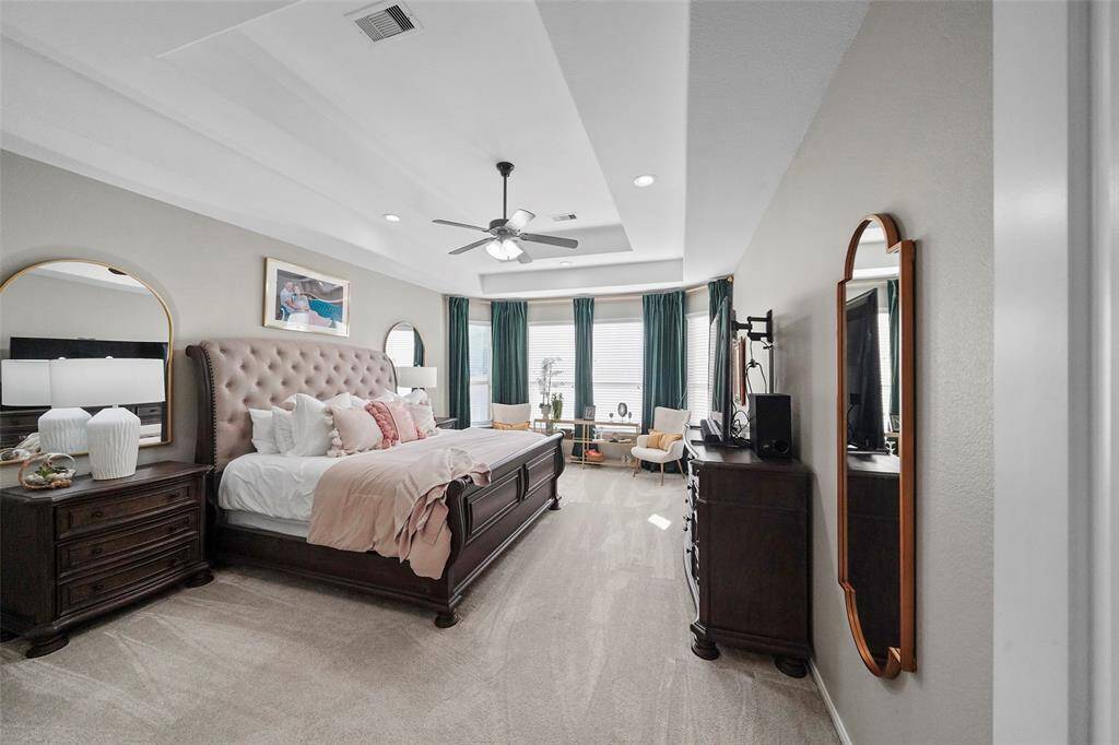 Large primary bedroom with double tray ceiling, bay window overlooking the pool and is large enough for another seating area.