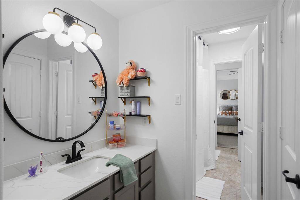 Sink area to the jack and jill bath on the second floor. A separate toilet/tub room is beyond with another bedroom.