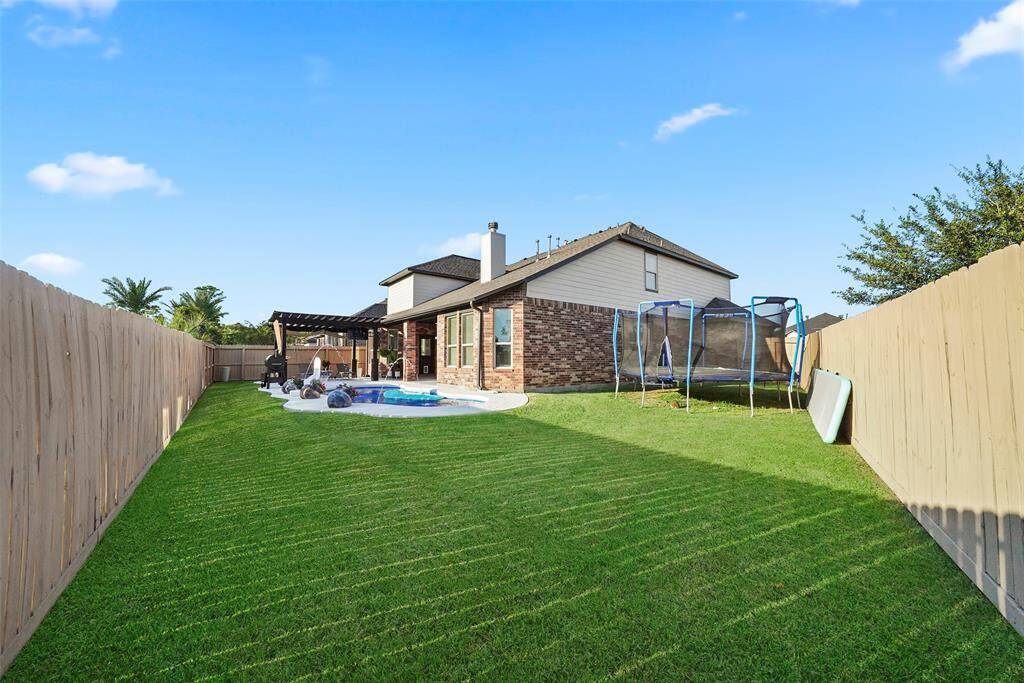 Green space beyond the pool for pets or outdoor games.