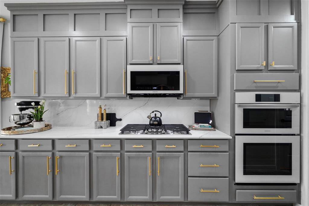 Updated Samsung Bespoke appliances include a microwave, gas cooktop and double ovens. The double convection ovens feature functions such as steam, air fry, bake and warm.