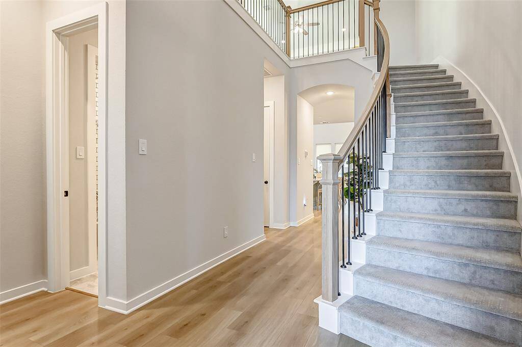 The sweeping staircase with upgraded luxury carpet sweeps down to a first floor that is bathed in beautiful French Oak wood floors.