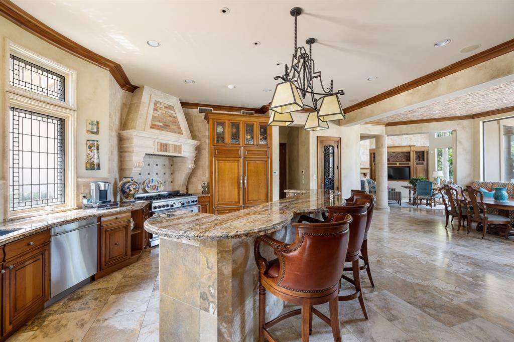 [Wet Bar] Off another axis of the Grand Entry is a Wet Bar between the Living Room to the left, and the Dining Room to the right. Above are more leaded glass clerestory windows, while the Bar itself is topped with granite countertops, equipped with a Scotsman ice machine and Subzero beverage refrigerator.