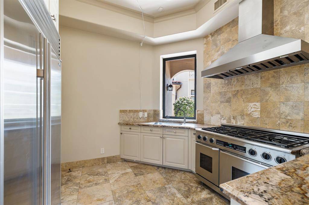 [Kitchen] This Connoisseur's Kitchen is well equipped with a Thermador six burner gas range and griddle with dual ovens, double ASKO dishwashers, and reverse osmosis drinking water faucet. Also within are a prep sink, microwave and copious amounts of cabinet and counter space for storage and preparation.
