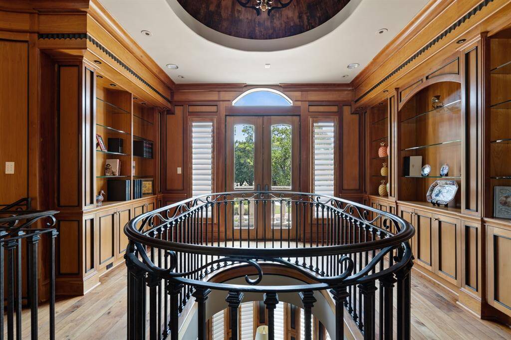 [Library - Main Level] Off yet another axis of the Grand Entry is the Executive Office & Library adorned with floor-to-ceiling custom African Teak millwork.