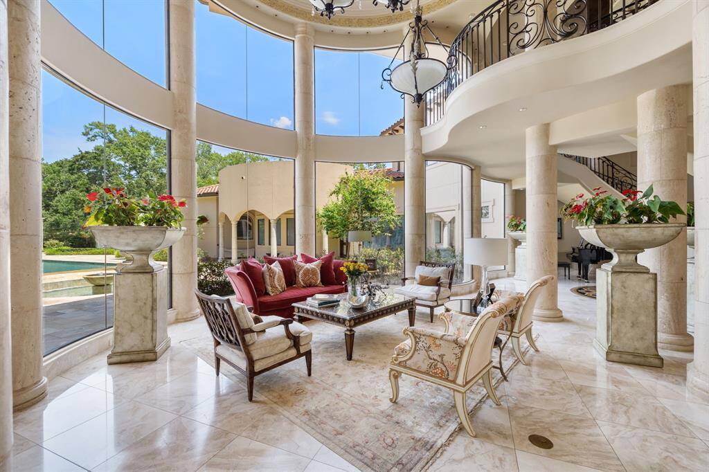 [Grand Foyer] Every aspect of this estate is regal. Mahogany French doors open to the Sala d'Ingresso—the Grand Foyer featuring a duple Iron & Teardrop Crystal Chandelier in a richly fauxed niche with the Indoor Sky Bridge at the center.