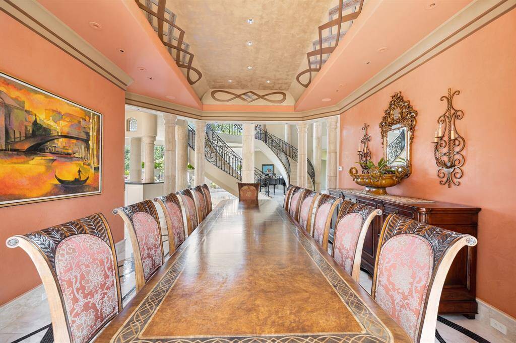 [Living Room] Within the Rotunda is the formal Living Room adorned with Baroque round stone columns, arched miniature leaded glass transom windows, and soaring double height butted glass windows with clear views of the Texas skies!