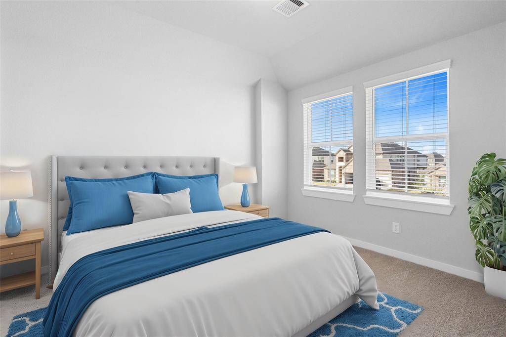 Secondary bedroom features plush carpet, neutral paint and large windows with privacy blinds.