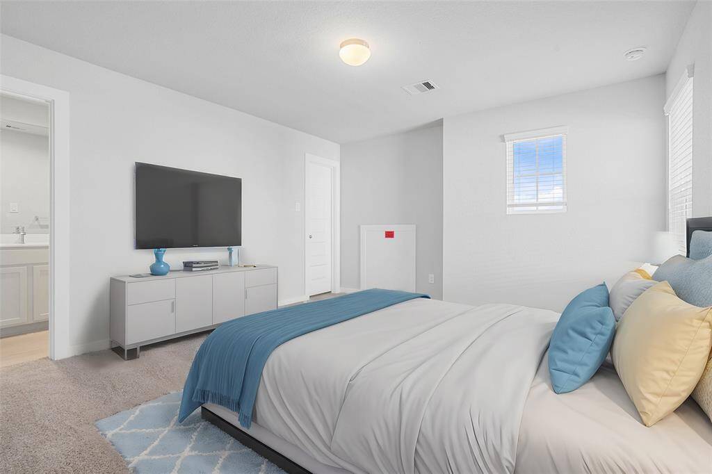 Secondary bedroom features plush carpet, neutral paint, large window with privacy blinds, and its own personal access to a secondary bathroom.