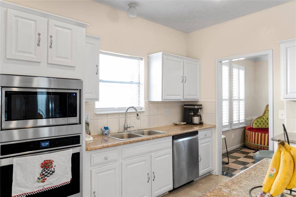 A spacious kitchen equipped with granite countertops and stainless steel appliances, ideal for cooking.