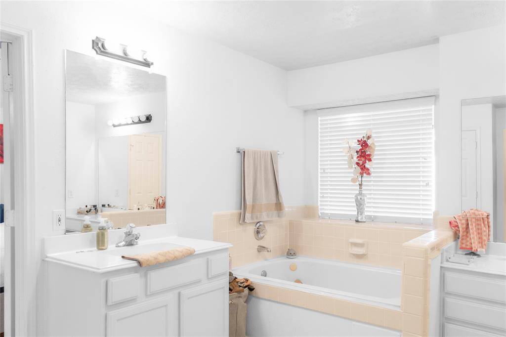A primary bath featuring a bathtub and double sink