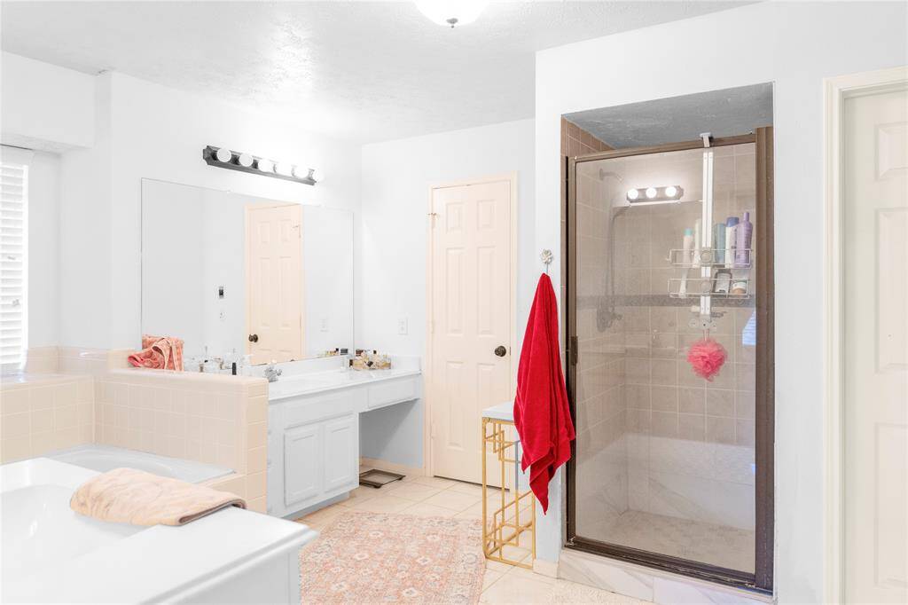 A walk-in shower with glass shower door.