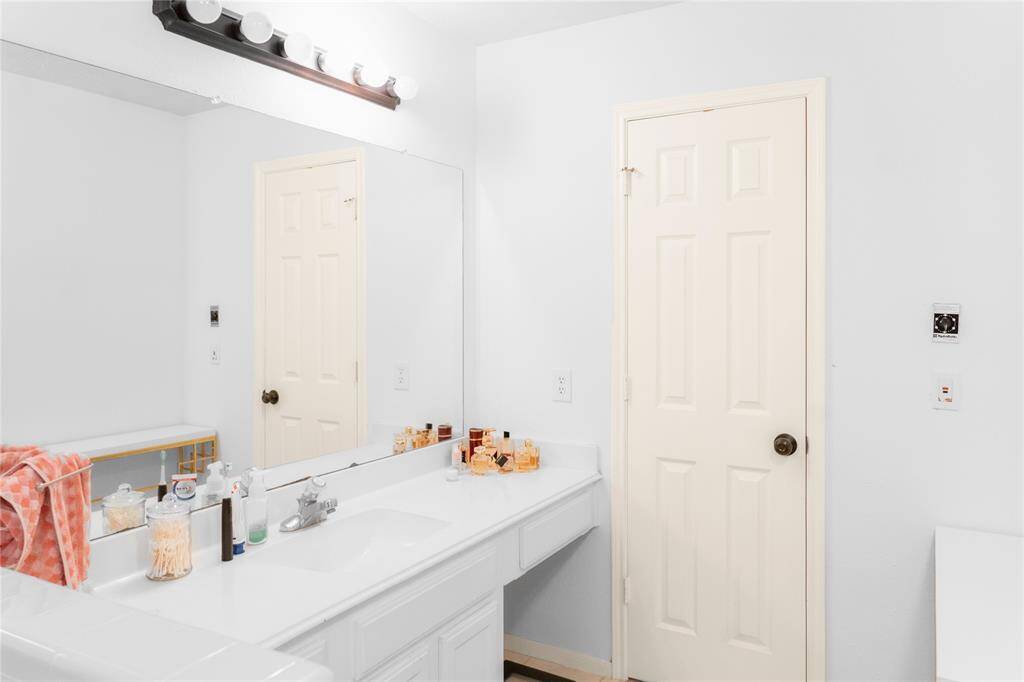 Second vanity with one of the two walking closet door.