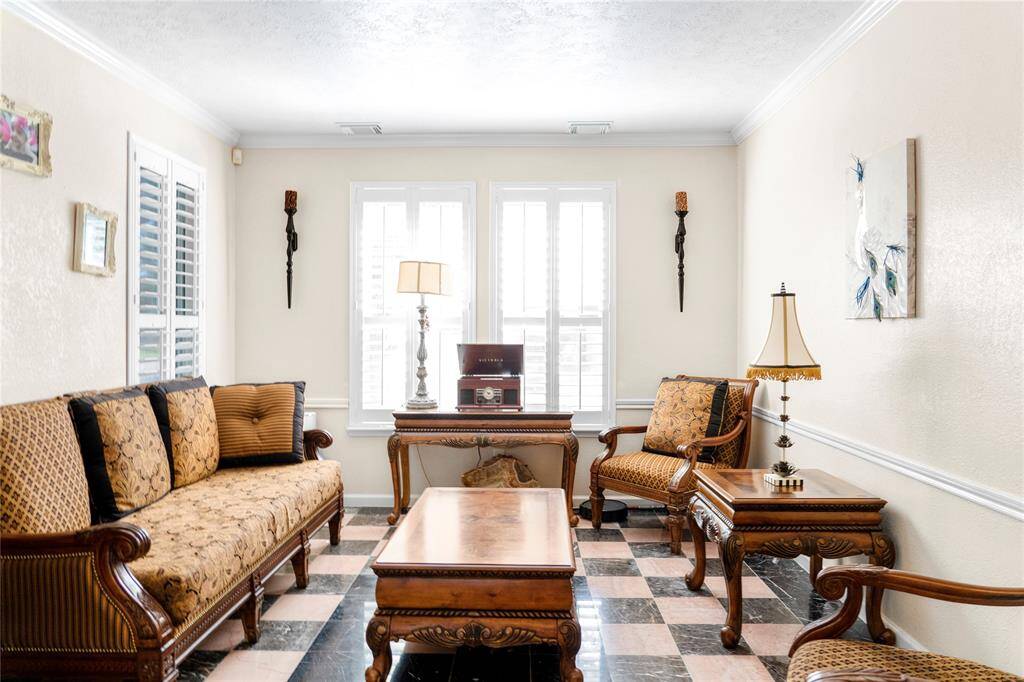 A formal living room featuring plantation shutters and marble flooring adds a touch of elegance.