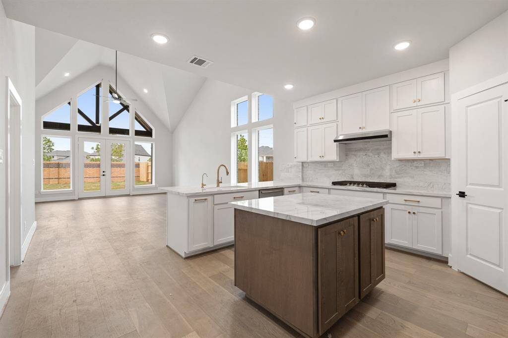 The Donley plan boasts an open kitchen flowing into the family room, featuring a vaulted ceiling for a spacious and airy feel.