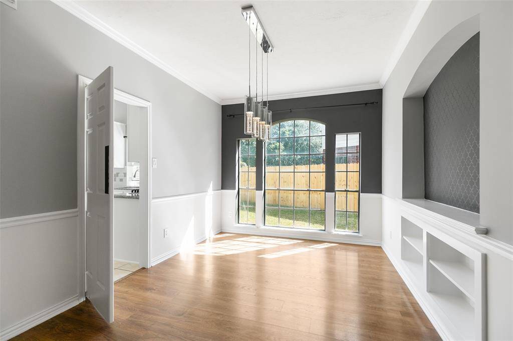 Elegant dining room can easily seat 8 or more. Upgraded pendant lighting creates a modern look. Push door leads to kitchen for easy serving access