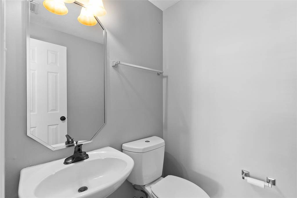 Powder bath with pedestal sink is located in a quiet corner.
