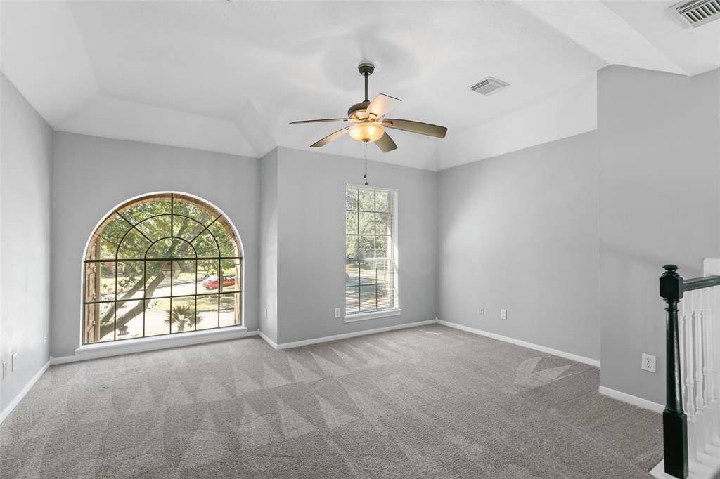 Upstairs game room has lots of natural light and a ceiling fan.