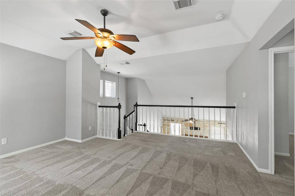 Open spindle staircase looks over living area.