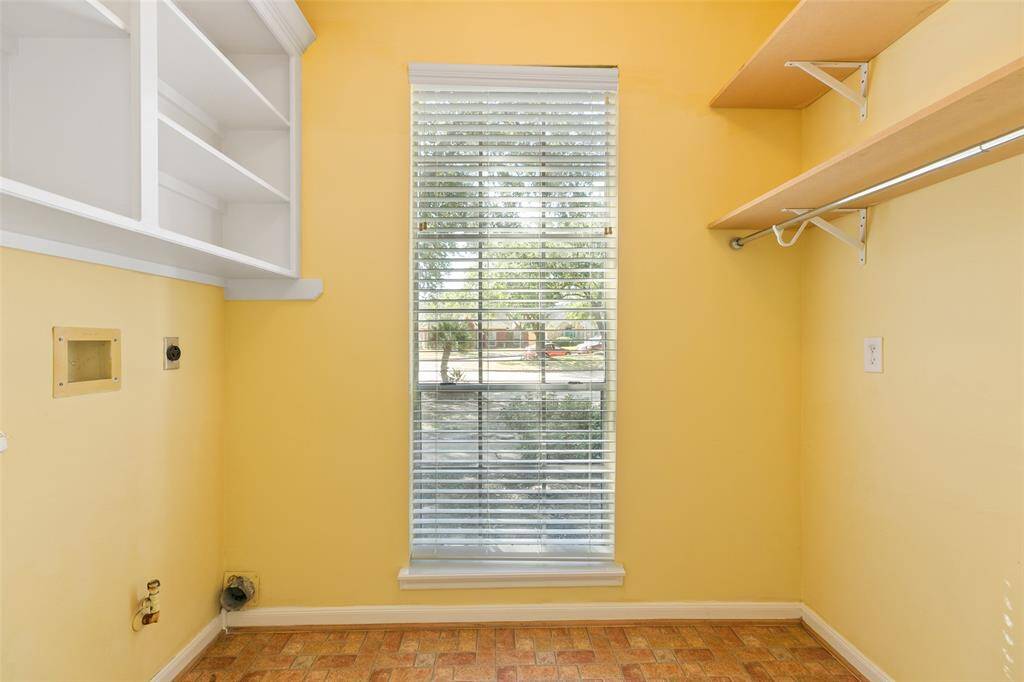 Large laundry room with window, hanging area and cabinets