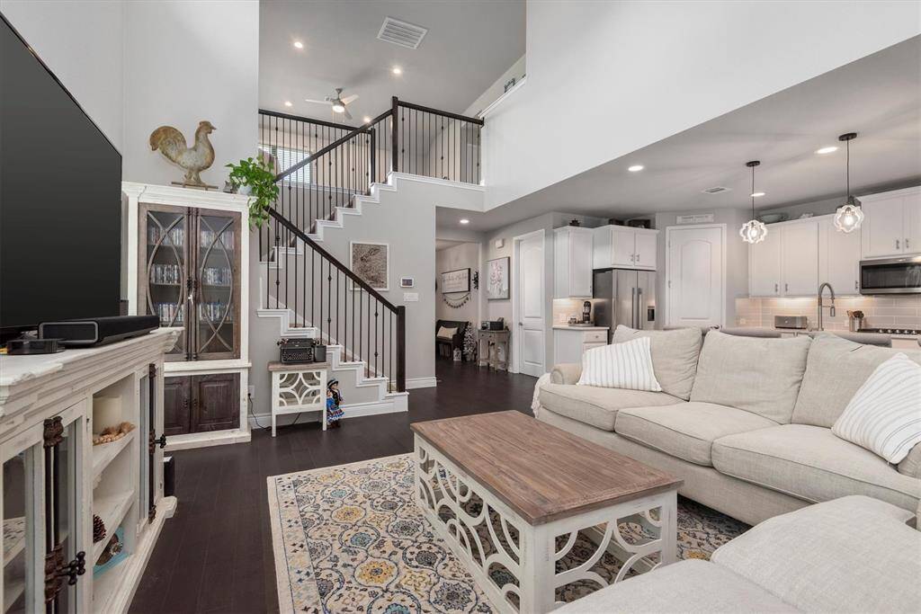 This Emerald DR Horton home showcases an open floor plan with high ceilings, a modern kitchen, a cozy living area, and an elegant staircase.