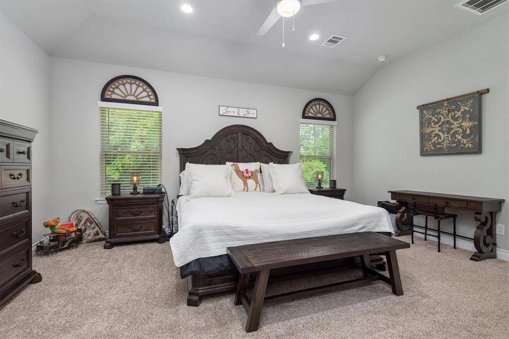 The high ceilings and large windows add to the primary bedroom.