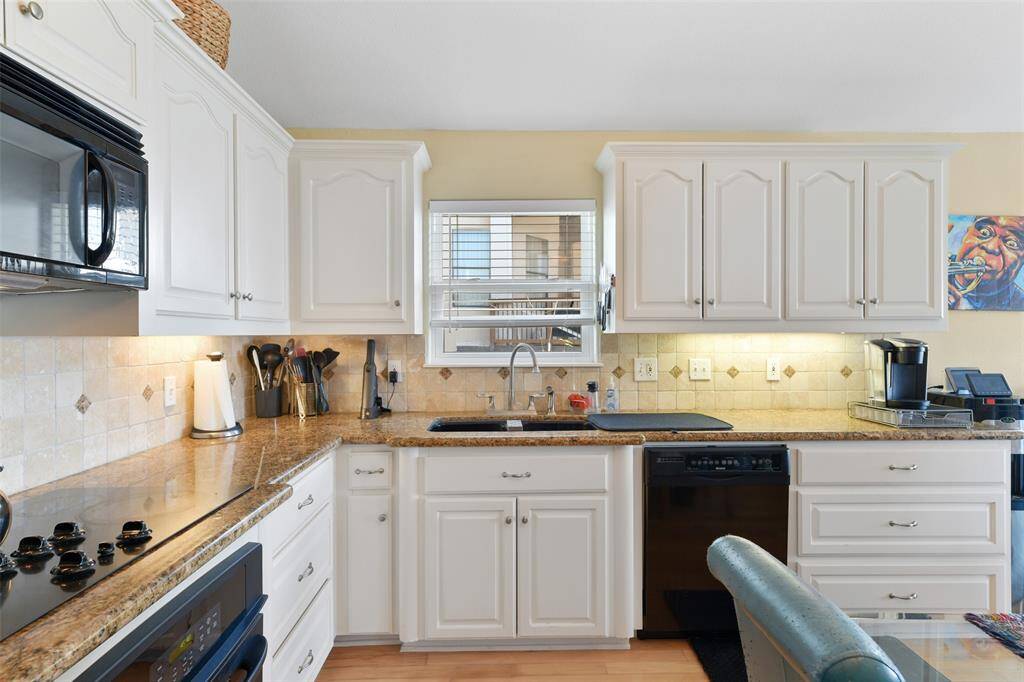 Soft under cabinet lighting and granite countertops surround the kitchen