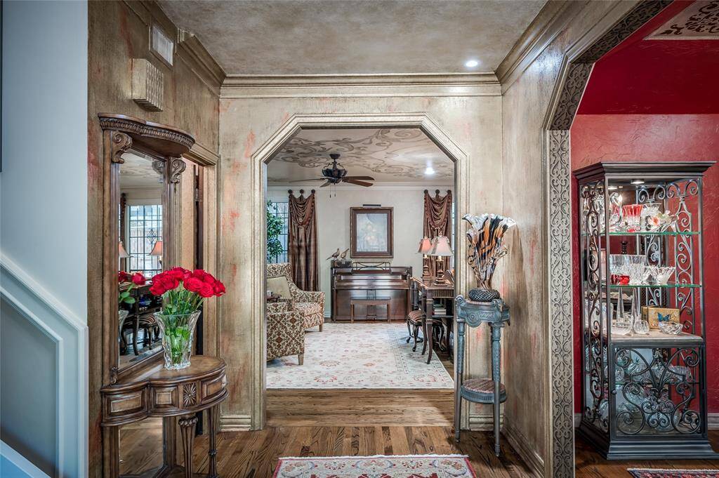 Graceful arched walkways guide you to the formal living and dining rooms featuring unique architectural details and custom stenciling. The beaded walls with gold and red faux paint emulate dupioni silk.